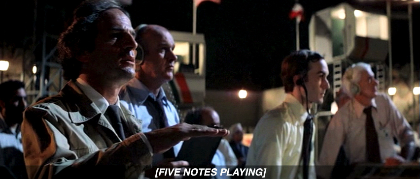 A frame from Close Encounters of the Third Kind showing Claude Lacombe making a Kodály hand sign for the film's famous five-note motif.
