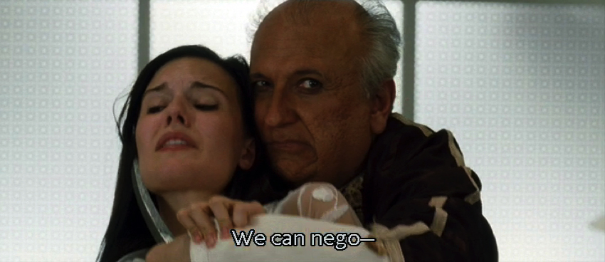A frame from Taken showing a bad guy holding a knife to a young woman's throat, with an interrupted caption demonstrating captioned irony.