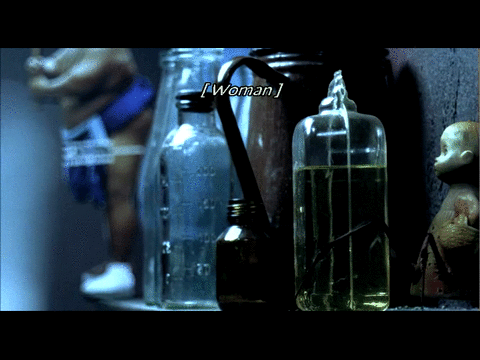 An animated gif from Night Watch featuring a subtitle that is covered by a bottle of oil that fall over: Hurry, stupid doll!