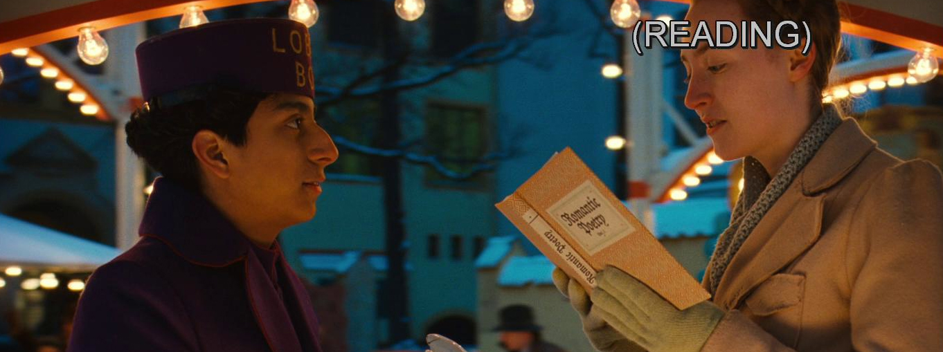 A frame The Grand Budapest Hotel (2014) featuring Zero (Tony Revolori) and his fiancé Agatha (Saoirse Ronan). They face each other. Agatha reads from a book entitled Romantic Poetry. The caption stamped on Agatha's forehead is (READING).