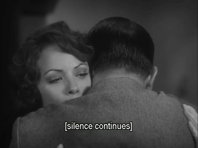 A frame from The Artist. An over the shoulder shot of George Valentin (Jean Dujardin) as he embraces Peppy Miller (Bérénice Bejo).